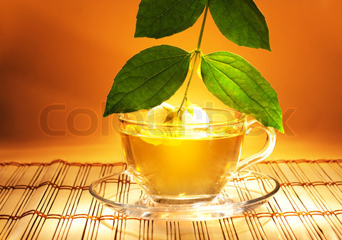 jasmine tea with fresh jasmine leaves and flowers in soft warm evening light